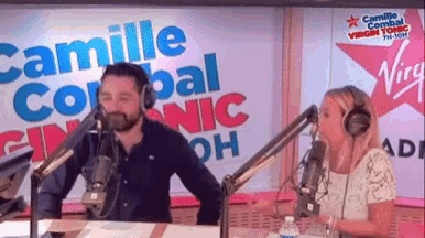 a man and a woman are talking into microphones in front of a sign that says camille corral