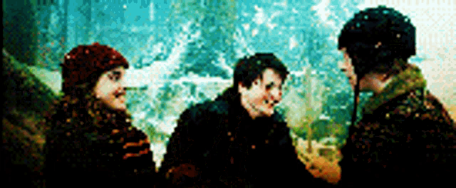 three people standing next to each other in a snowy forest