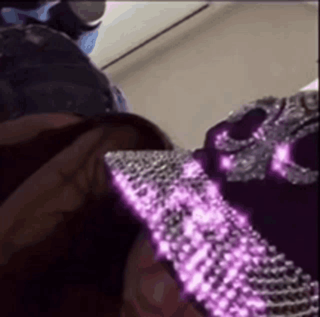 a woman wearing a purple hat with rhinestones and a skull on it .
