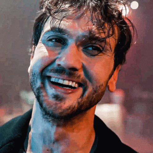 a close up of a man 's face with a smile on his face