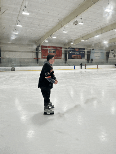 a young boy ice skating in front of a sign that says ' ice hockey players '