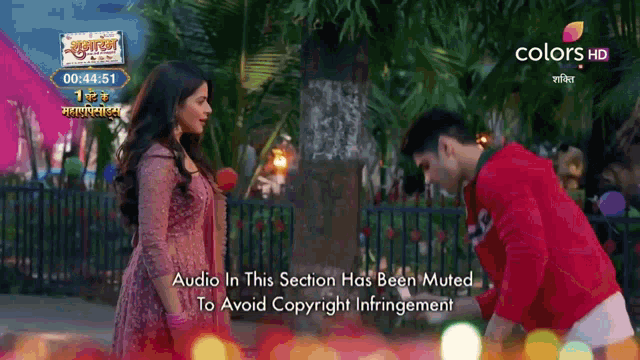 a man and a woman are standing next to each other in front of a sign that says colors hd