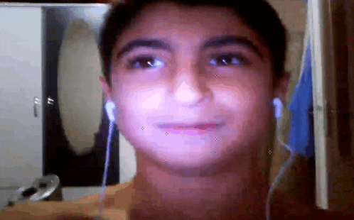 a young boy wearing headphones looks at the camera and smiles