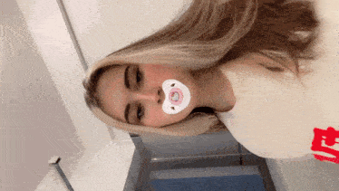 a girl wearing a pink hello kitty pacifier
