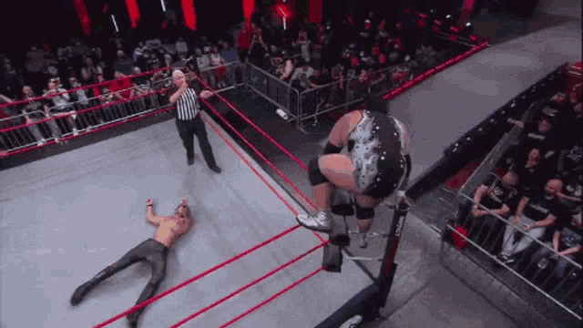 a wrestler is jumping over another wrestler in a ring