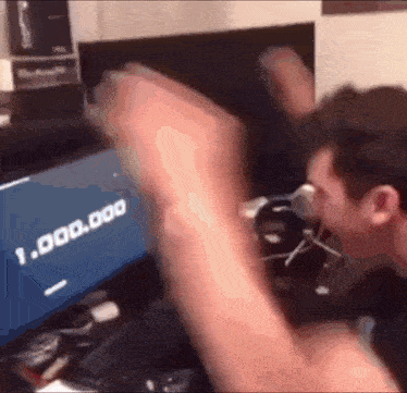 a man is sitting in front of a computer screen that says 1,000,000 on it