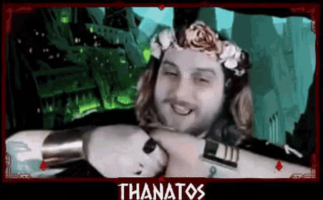 a man with a flower crown on his head is smiling and holding a sword .