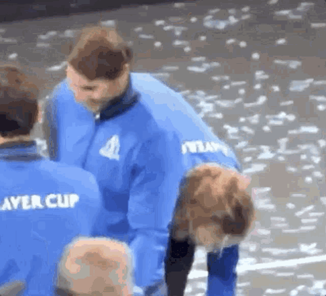a group of people wearing blue jackets with player cup written on the back