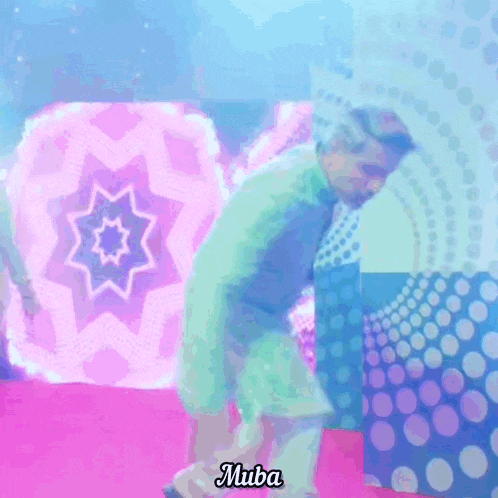 a man in a green shirt and white pants is dancing in front of a screen that says muba on it