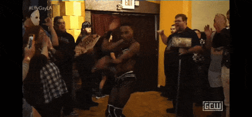a man dancing in front of a crowd with a sign that says ggw