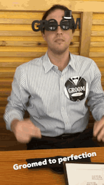 a man wearing a groom pin on his shirt
