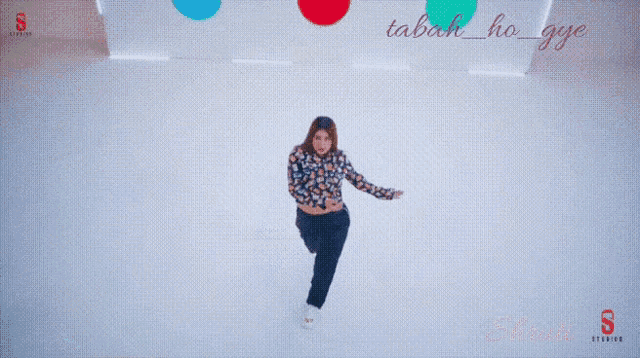 a woman is dancing in front of a sign that says tabah_ho_ge