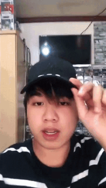 a young man wearing a hat and a striped shirt