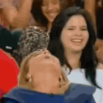 a group of people are sitting in a stadium and one of them is looking up
