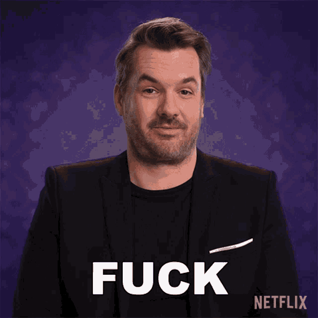 a man in a suit and black shirt says fuck