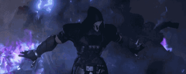 a man in a hood is holding a gun in a dark room .