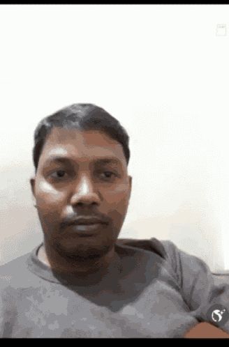 a man wearing a grey shirt with the letter s on the arm