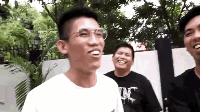a group of young men are standing next to each other smiling and laughing .