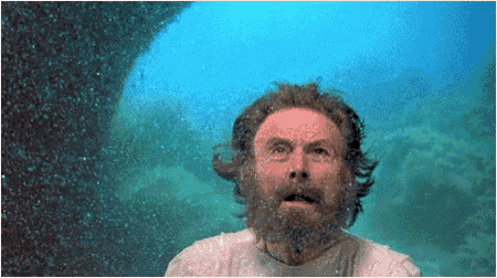 a man with a beard and a white shirt is standing in the water