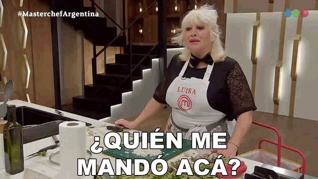 a woman wearing an apron that says luisa stands in front of a kitchen counter