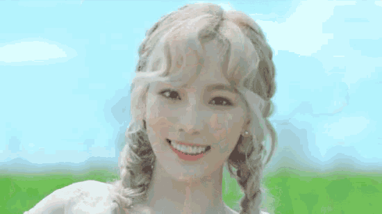 a woman with blonde hair is smiling in a field .