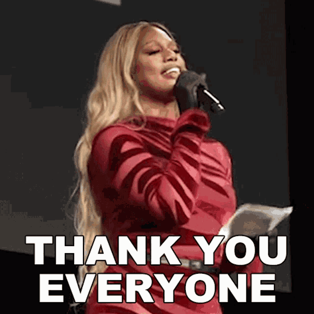 a woman in a red dress is singing into a microphone with the words thank you everyone below her