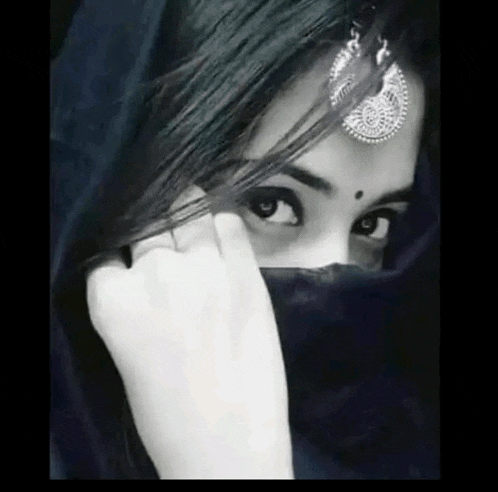 a black and white photo of a woman covering her face .
