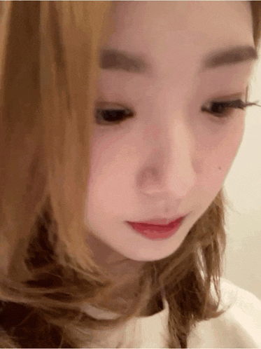 a close up of a woman 's face with long hair and red lips .