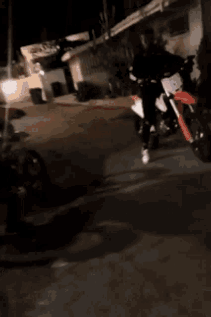 a person is riding a dirt bike on the street at night .