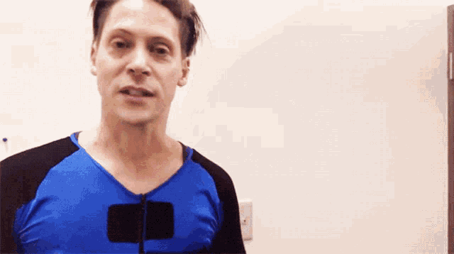 a man is wearing a blue shirt with a black sleeve
