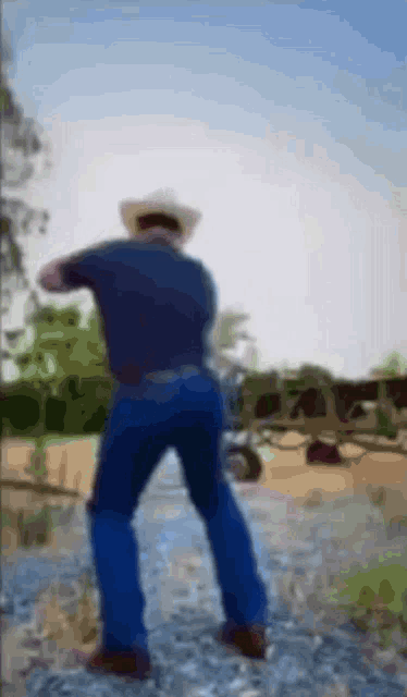 a blurry picture of a man wearing a cowboy hat and jeans