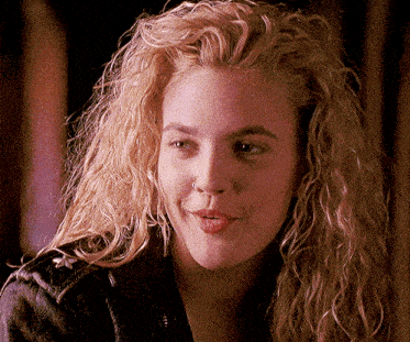 a close up of a woman 's face with blonde curly hair