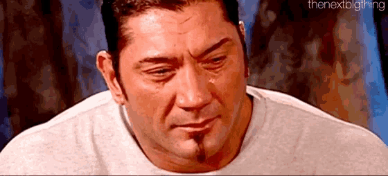 a close up of a man 's face with a tear running down his face .