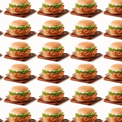 a repeating pattern of fried chicken sandwiches on wooden plates