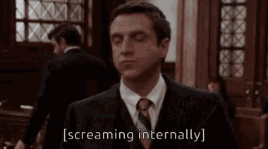 a man in a suit and tie is screaming in a courtroom in front of a group of people .