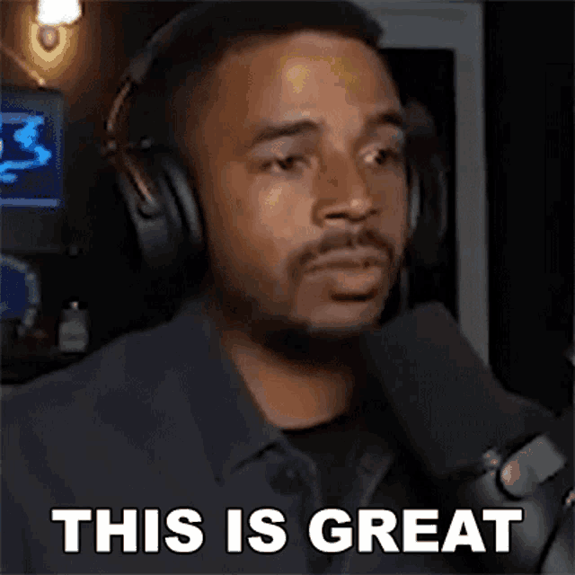 a man wearing headphones is talking into a microphone .