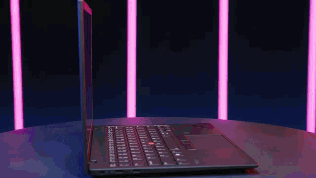 a laptop is open and sitting on a table with pink lights in the background