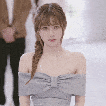 a woman in a grey off the shoulder dress with a braid