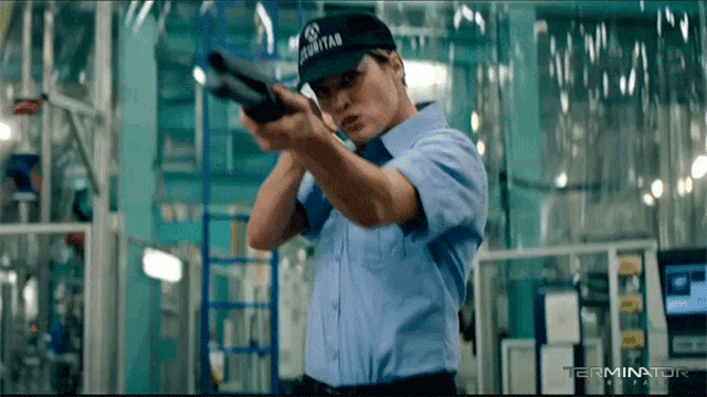 a man wearing a security hat is pointing a gun at something