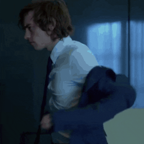 a man in a suit and tie is standing in a room