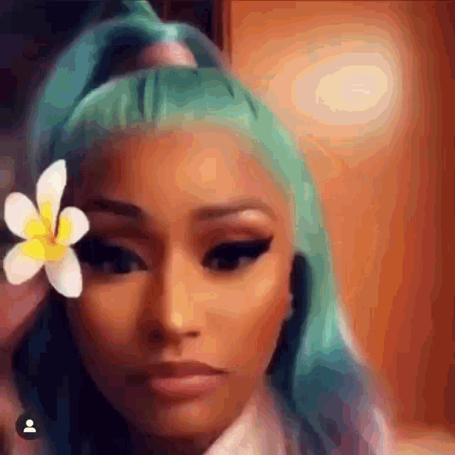 a woman with green hair is holding a white flower in her hair .