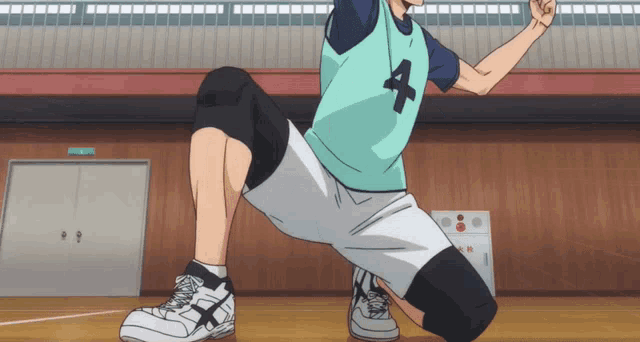 a man with the number 4 on his shirt is squatting down