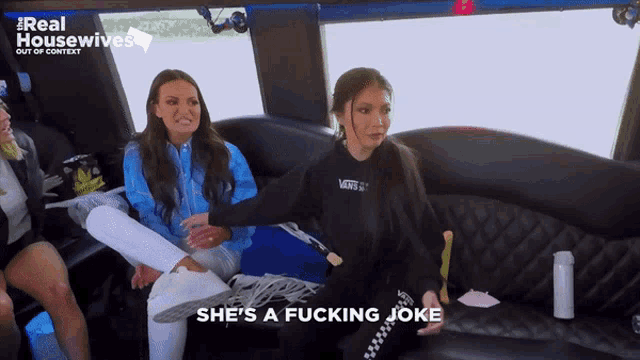 two women are sitting in a limousine with the words she 's a fucking joke on the screen