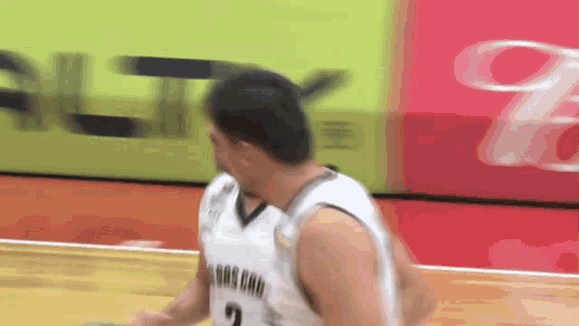 a basketball player wearing a number 2 jersey dribbles the ball