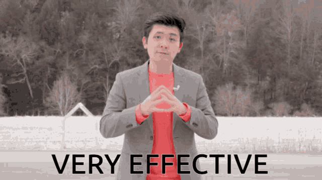 a man in a suit and red shirt stands in front of a sign that says very effective