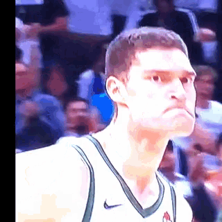 a basketball player wearing a nike jersey looks to the side