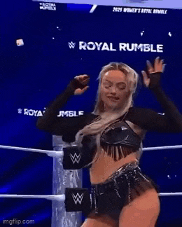 a woman is dancing in a wrestling ring while holding her hair .