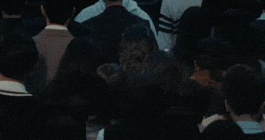 a woman with a backpack stands in a crowd