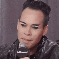 a man wearing a leather jacket is talking into a microphone .