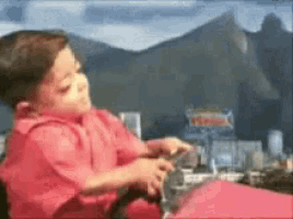 a boy in a red shirt is playing with a toy car
